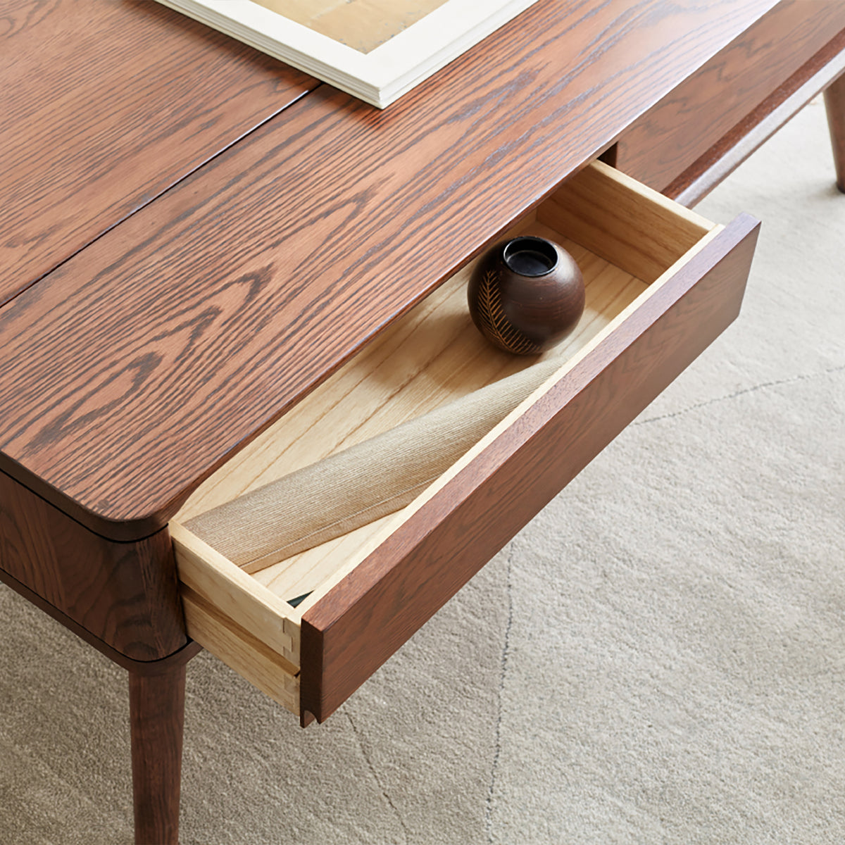 Nyborg storage coffee table in natural wood beside a sofa