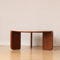 Linden round coffee table in brown beside a chair