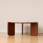 Linden round coffee table in brown beside a chair
