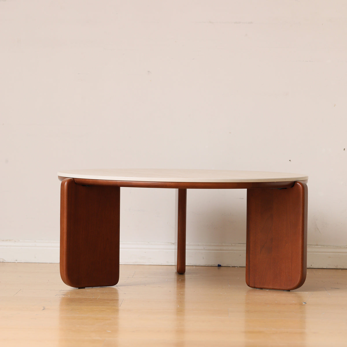 Linden round coffee table in brown beside a chair