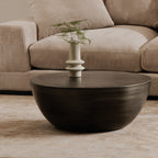 Corniche round metal coffee table in brushed silver, in a living room