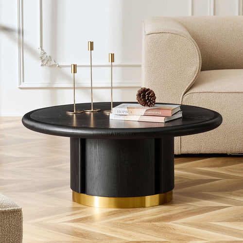 Fontaine round coffee table in black on a cylindrical base, in a living room